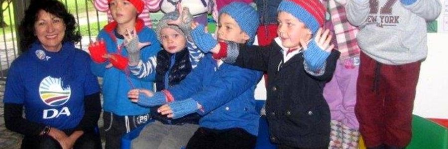 Die kleuters by Cool Kids is duidelik beÃ¯ndruk met hulle mussies en handskoene, met rdl Riana de Coning by hulle.  